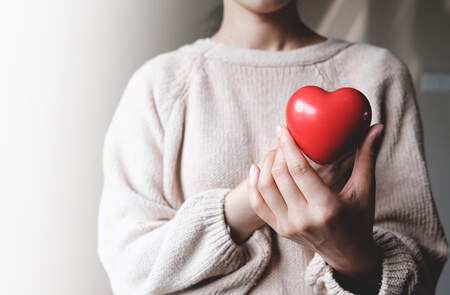 Frau hält Herz in der Hand