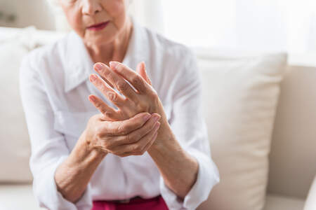 Frau hält ihre eine Hand fest